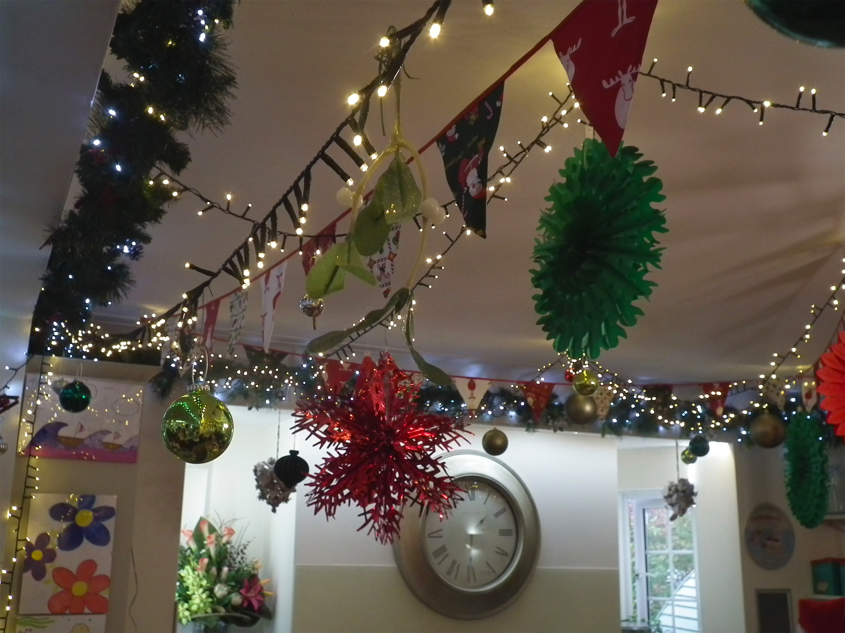 Close-up photo of the Christmas decorations showing garlands, fairy lights, mistletoe and paper decorations