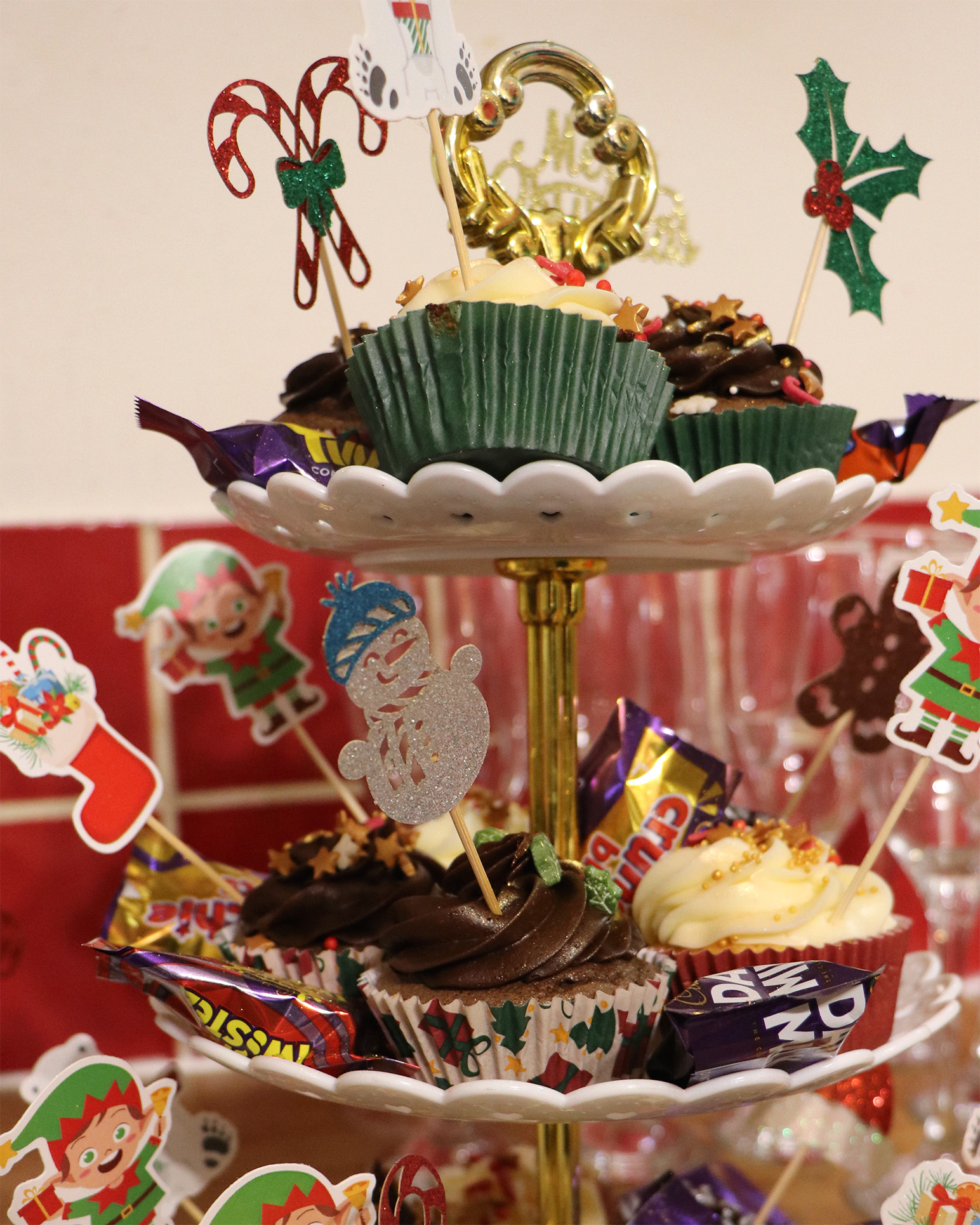 Festive cupcakes with chocolate and vanilla icing, with snowman and elf decorations.